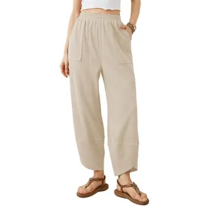 Full view of women's beige loose lantern pants with elastic waist and side pockets.