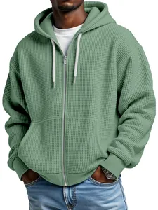 Dettaglio di una felpa con cappuccio e zip da uomo in maglia a nido d'ape verde oliva.