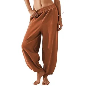 Loose fit women's harem pants with elastic waist and pockets in a warm rust brown color.