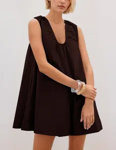 Detail shot of the V-neck and pleated neckline of a dark brown sleeveless dress.