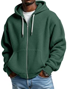 Primo piano di una felpa con cappuccio e zip in maglia a nido d'ape verde scuro da uomo