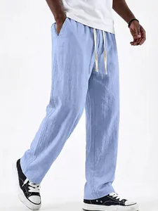 Close-up of men's light blue linen drawstring pants showing texture and straight leg cut