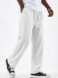 Close-up of white linen straight-leg trousers for men with adjustable drawstring