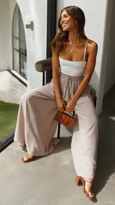 Detailed view showing the relaxed fit and drawstring waist of the beige wide-leg pants