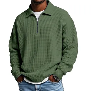 Close-up of olive green waffle knit texture on men's half-zip polo shirt