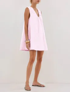 Detail of pink pleated V-neck sleeveless mini dress on model in studio