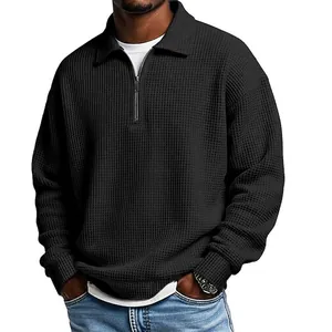 Detail view of men's black waffle knit polo shirt with quarter-zip and lapel collar