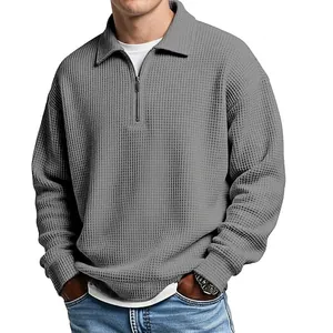 Close-up detail of a grey waffle-knit polo shirt showing the collar and zip-up area