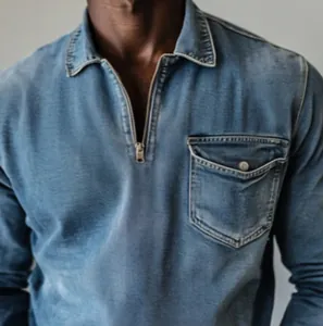 Close-up detail of a men's blue denim quarter-zip shirt featuring a chest pocket.