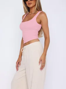 Detail view of a stylish women's pink double-layered sport tank top with linen pants