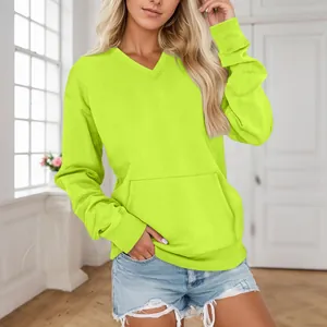Modell trägt neon limettengrünes Sweatshirt mit V-Ausschnitt und praktischer Tasche.