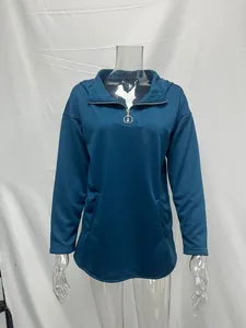 Detalle de sudadera verde azulado con media cremallera y tirador de anillo