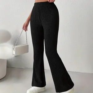 Primo piano di pantaloni neri a zampa a vita alta a coste, che mostrano la vestibilità aderente