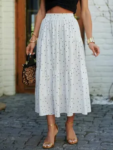 Close-up detail of white tiered midi skirt with black polka dot print and elastic waist