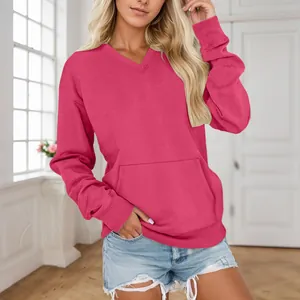 Frau trägt ein modisches leuchtend rosa Oversize-Sweatshirt mit V-Ausschnitt