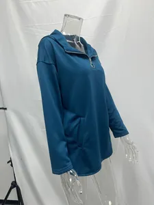 Vista lateral de una sudadera con capucha oversize azul cerceta con media cremallera