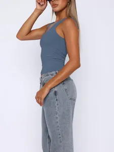 Side view of a blue double-layered athletic tank top for women in a studio setting.
