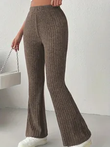 Dettaglio dei pantaloni svasati a costine marroni a vita alta con texture
