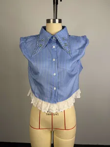 Close-up of blue striped shirt featuring a beaded collar and white lace hem detail
