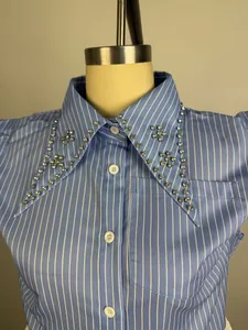 Close-up of vertical striped shirt with rhinestone embellished collar and pocket