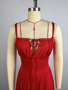 Detailed close-up of an elegant pleated high-waisted red maxi dress with a bow tie.