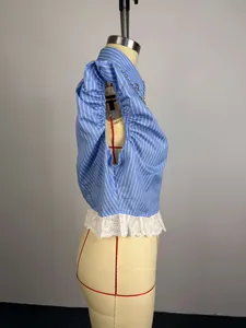 Side view of a blue striped short-sleeve shirt with beads and lace hem detail