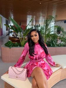 Model wearing a stylish pink floral print A-line mini dress with elegant pleated details