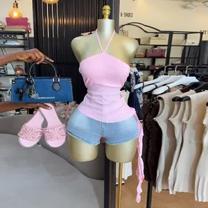 Detailansicht eines rosa Halterneck-Tops mit unregelmäßigem Rüschensaum im Shop