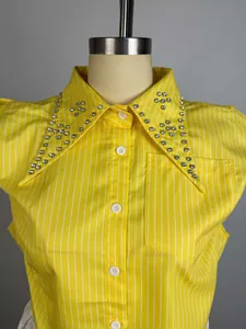 Close-up of a yellow striped shirt with a sparkling rhinestone-embellished pointed collar.