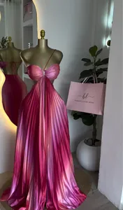 Vista detallada de un vestido maxi plisado rosa con cuello halter y abertura en cintura