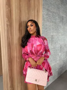 Chic pink floral print pleated A-line mini dress with high neck and long sleeves on model
