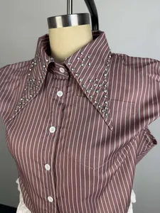 Detailed macro view of rhinestone embellished collar on a mauve striped satin shirt