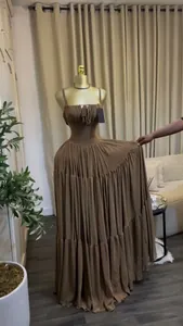 Elegant brown pleated maxi dress with spaghetti straps shown on mannequin 80-100 characters