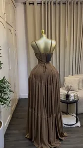 Detailed back view showing the corset tie of an elegant brown pleated maxi dress.