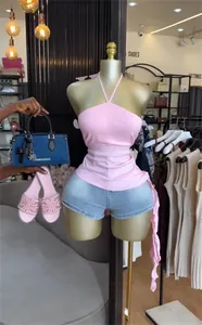 Detailansicht eines rosa Neckholder-Tops mit unregelmäßigem Rüschensaum am Mannequin