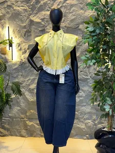 Fashionable yellow striped shirt with beaded collar and ruffled hem on mannequin