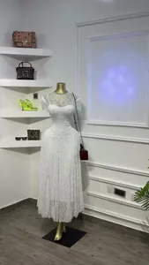 Elegante witte kanten midi-jurk met korte mouwen en pailletten op de paspop