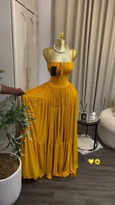 Elegant mustard yellow pleated maxi dress with spaghetti straps and tiered skirt detail.