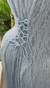Detail van lichtblauwe kanten jurk met vetersluiting en glinsterende pailletten