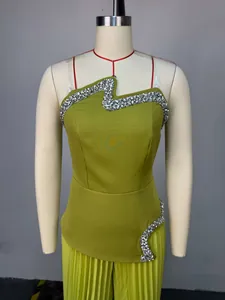 Detailansicht des grünen Sets aus Strass-Bandeau-Top und plissierter weiter Hose.
