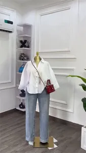 Minimalistisches lockeres weißes Hemd mit Kragen auf Schaufensterpuppe mit Jeans kombiniert