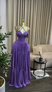 Close-up of elegant purple pleated high-waist maxi gown with unique criss-cross straps.