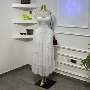 Gedetailleerd overzicht van een elegante witte kanten maxi-jurk met korte mouwen op pop