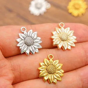 Vue détaillée de trois pendentifs tournesol en métal aux finitions argent et or.