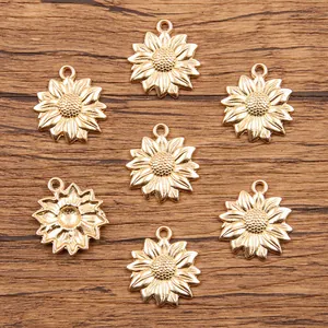 Vue détaillée de sept breloques tournesol dorées pour bijoux DIY sur fond de bois rustique.
