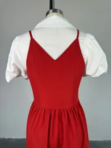Detail of faux two-piece dress featuring white puff sleeves and a red V-neck bodice.