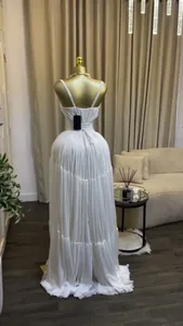 Rear view of elegant white pleated high-waisted maxi dress displayed on mannequin