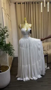 Detail of elegant white tiered maxi dress with pleated bodice and long flowing skirt.