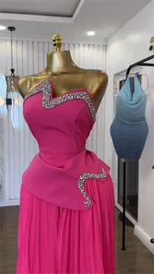 Detailansicht eines pinkfarbenen trägerlosen Tops mit Strassbesatz und Faltenhose