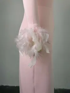 Nahaufnahme der luxuriösen, flauschigen rosa und weißen Federbündchen an einem Kleid